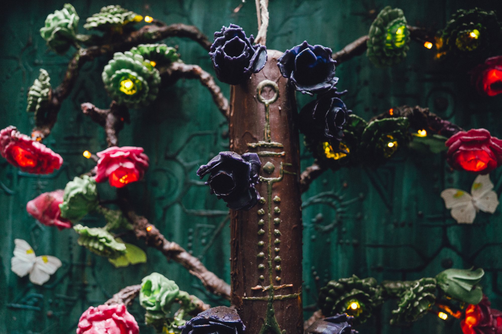 Roses and lights along the carved trunk at night