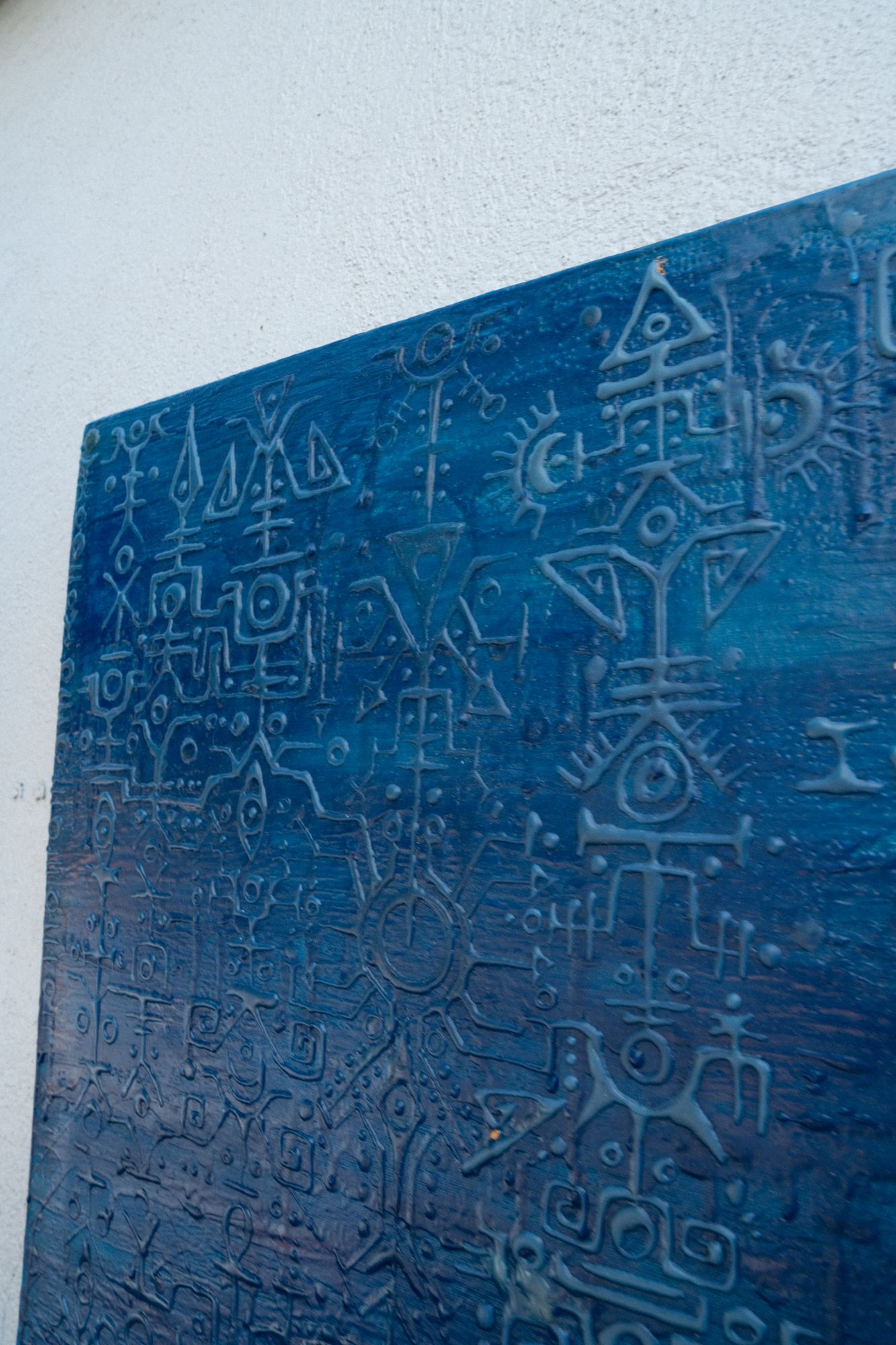 Lenguaje I: blue relief painting carved with glyphs and inscriptions