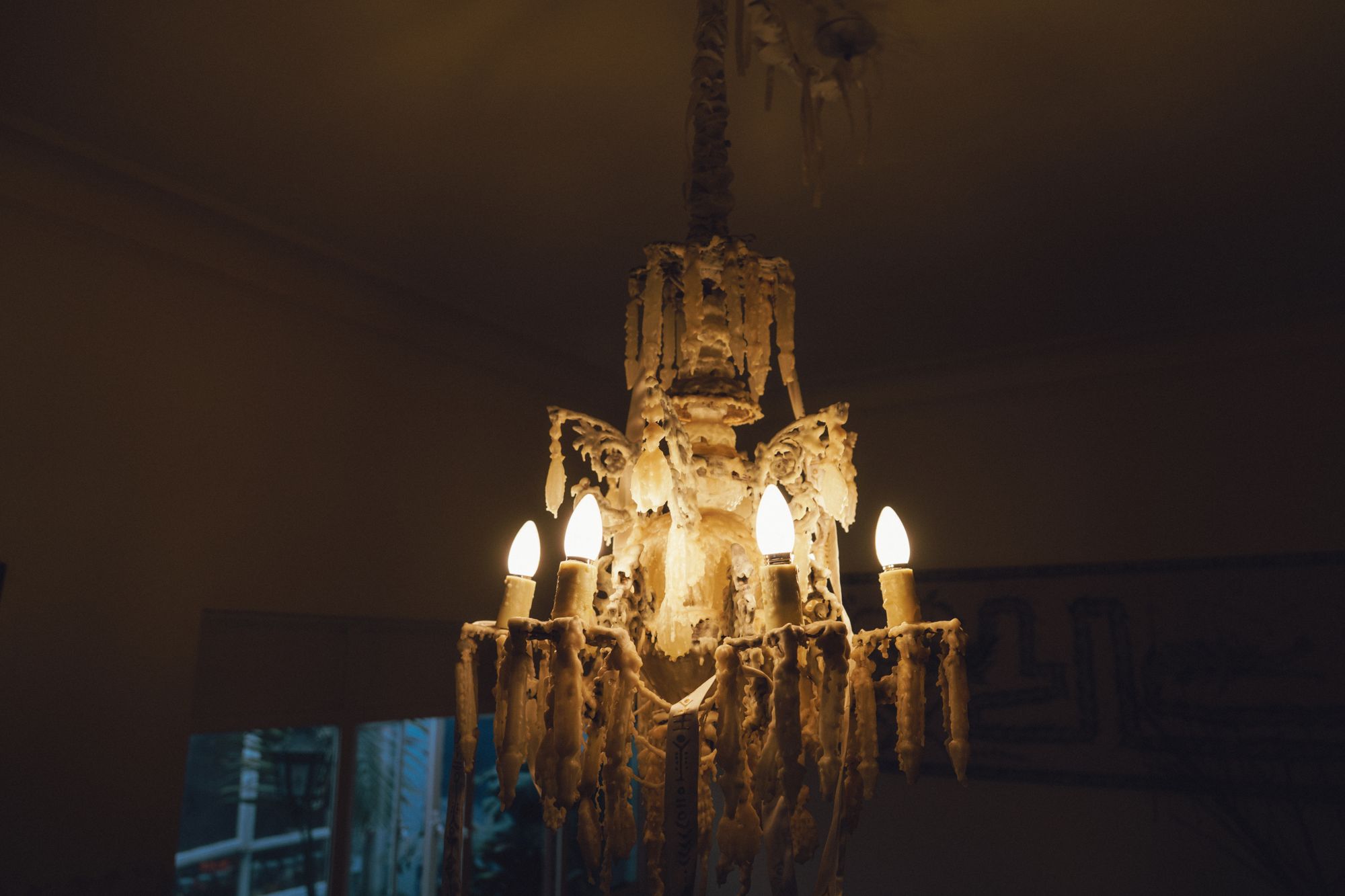 Candelabro glowing in a dark room, wax dripping from every arm