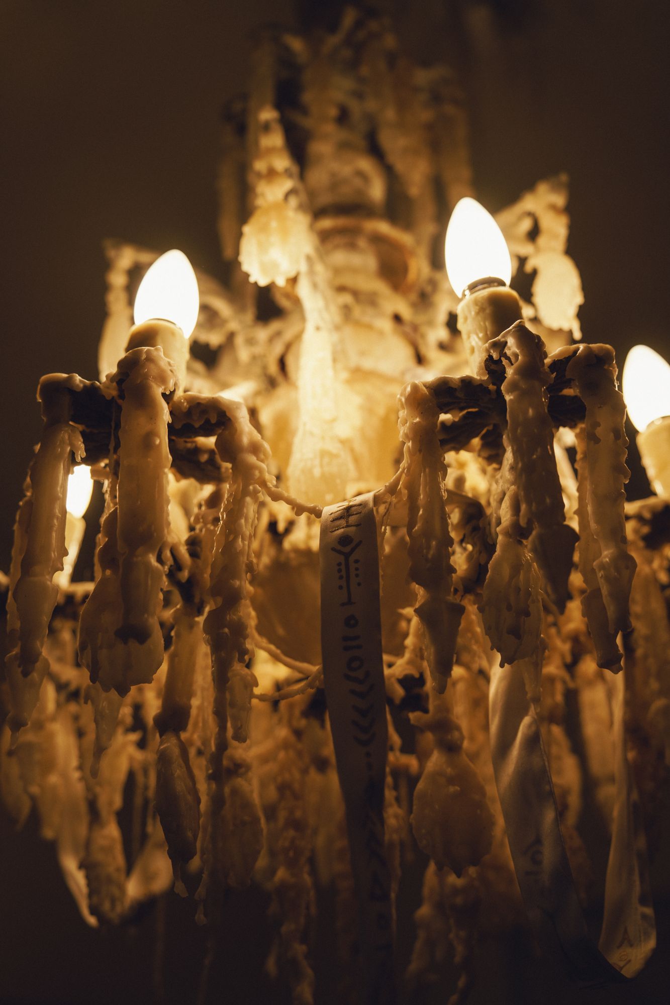 Memorias de cera: crystal chandelier encrusted in dripping wax, lit from within