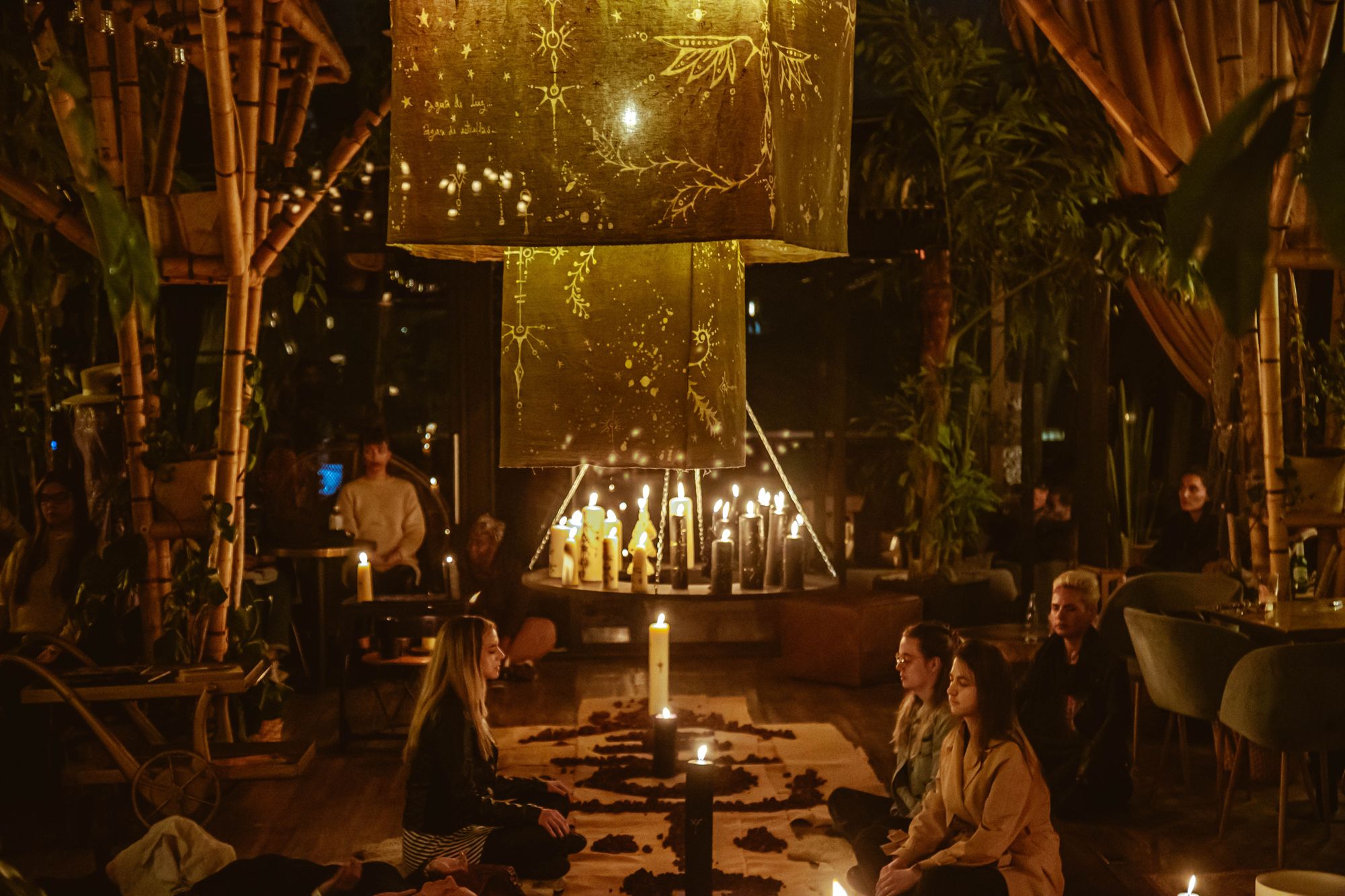 Candlelit ceremonial gathering under a canopy
