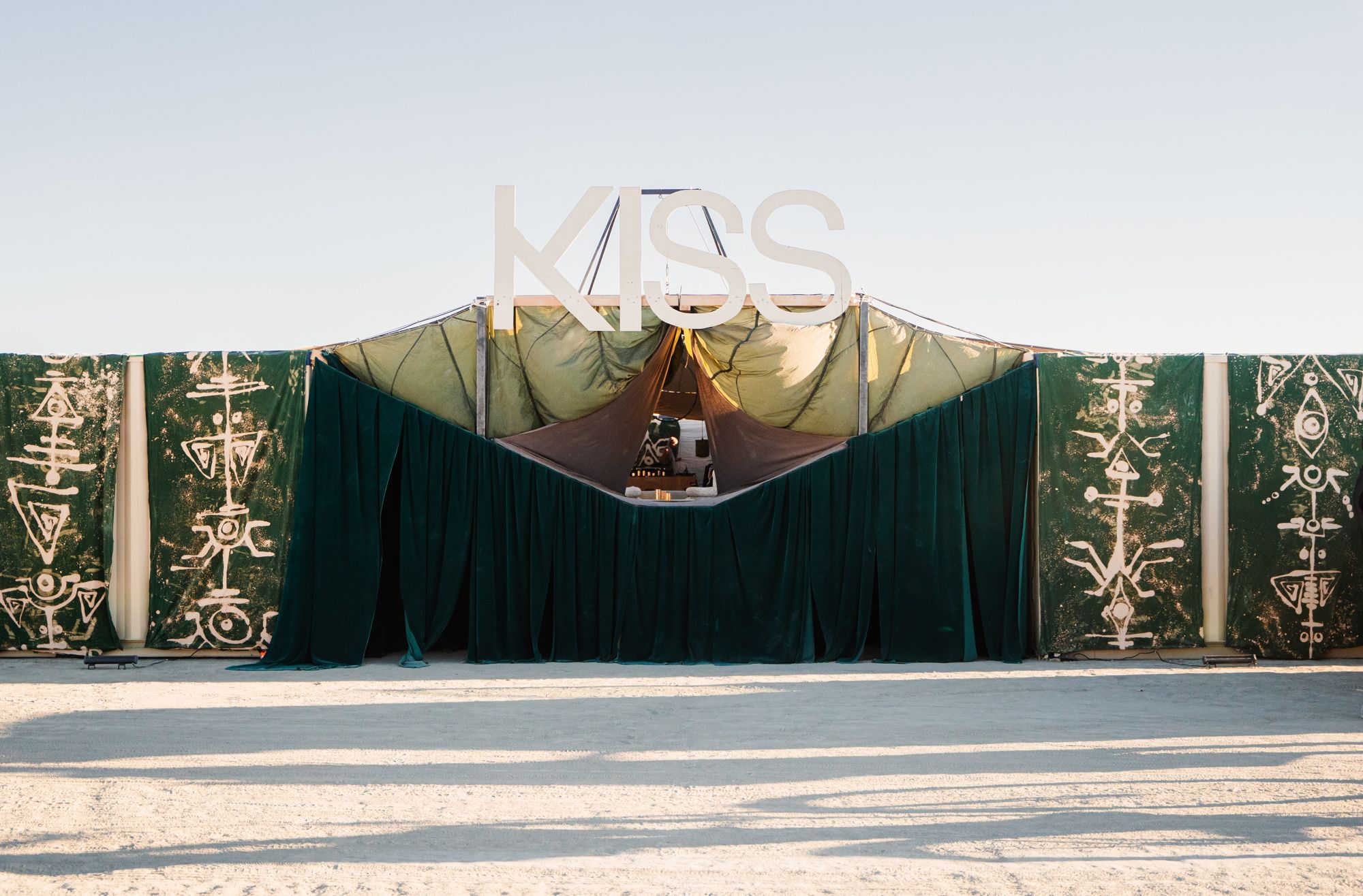 Embroidered green velvet stage set standing in a white desert
