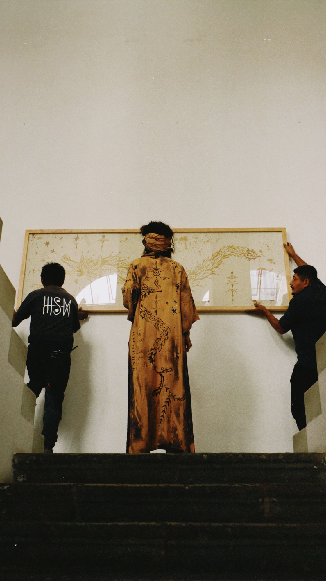 The framed codex carried up an outdoor staircase