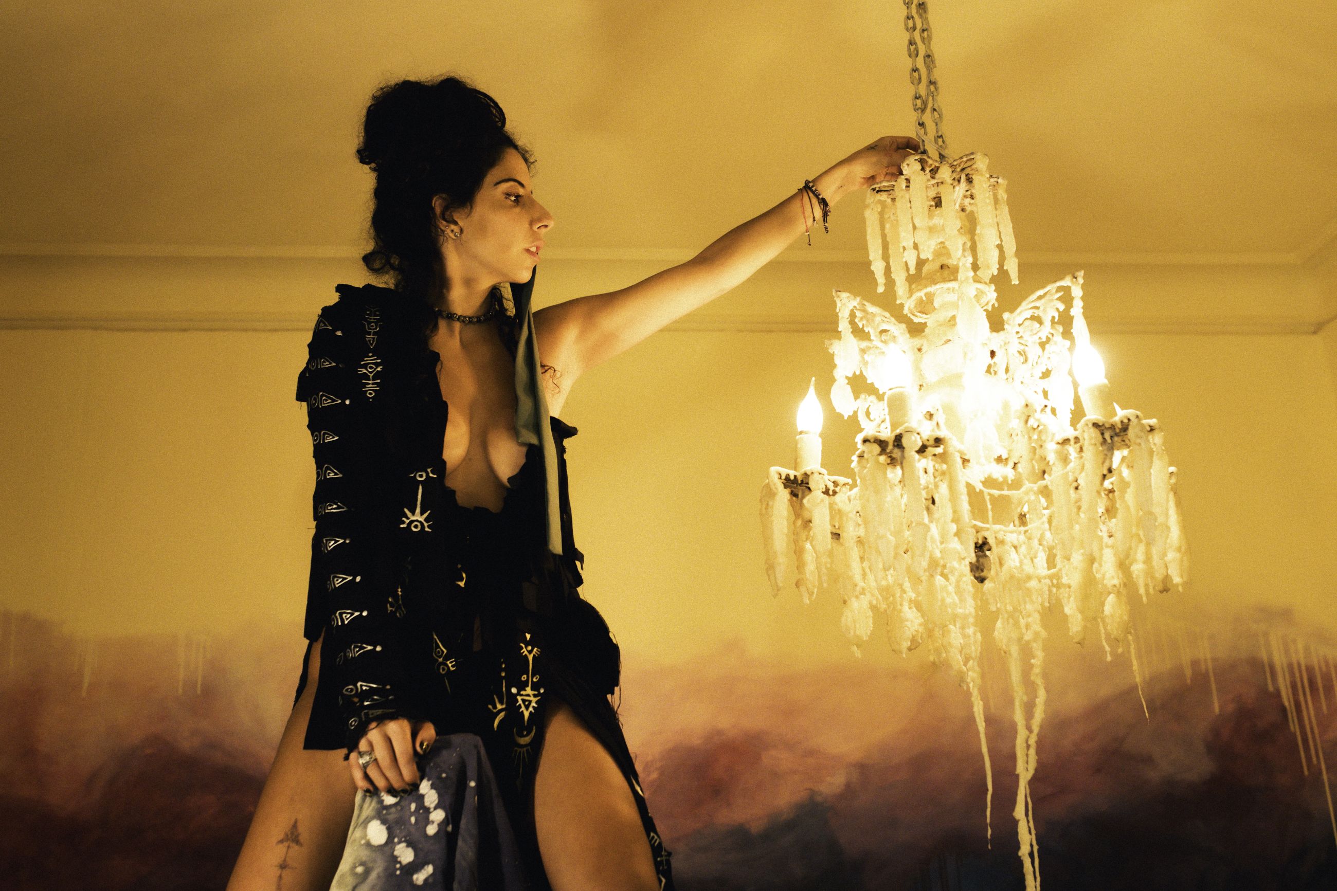 Pau Malo at dusk, reaching toward a glowing wax-dipped chandelier